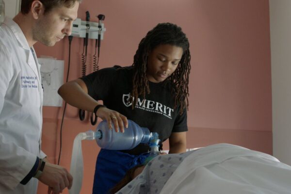 Dr. Galiatsatos working with a teen from MERIT, a program which helps mentor under-represented teens into health care leaders.