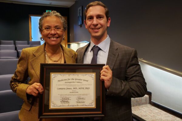 Camara Jones receiving a certificate for giving a distinguished address at our 2018 MGG Symposium.